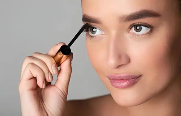 Femme appliquant l'huile d'argan sur les cils